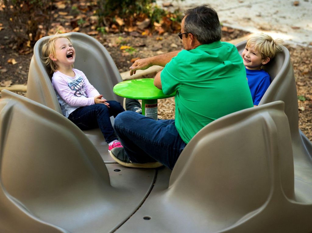 Parents and children participating on inclusive merry-go-round