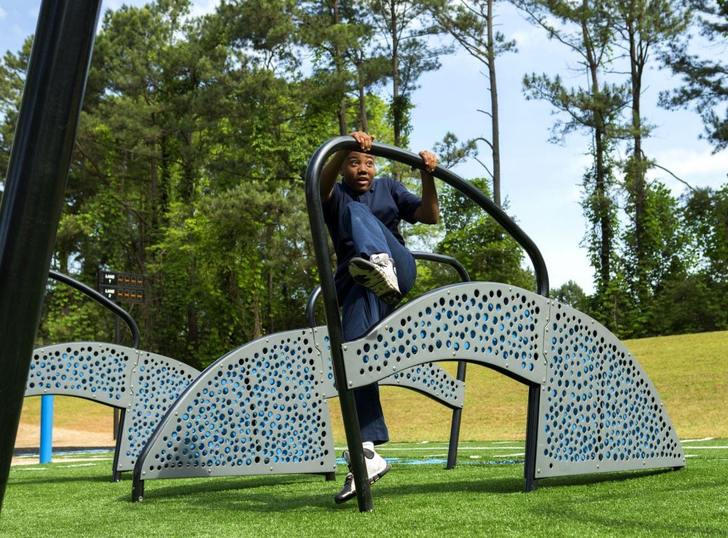 Teenage boy navigating an outdoor agility obstacle course